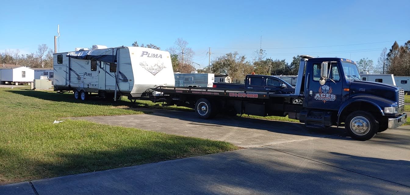Flatbed truck towing a Puma travel trailer